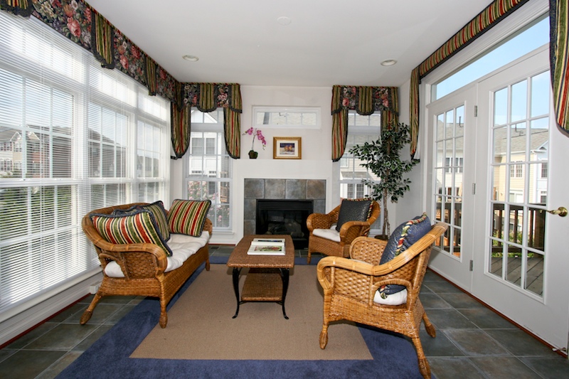 Sunlit Sunroom with fireplace and opens to deck